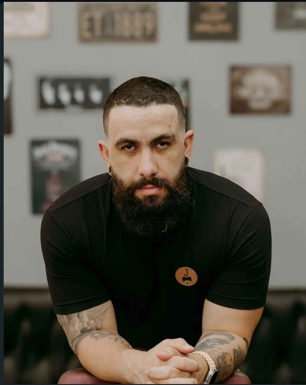 Bobê, barbeiro da Valete, de camiseta preta com o logo da barbearia