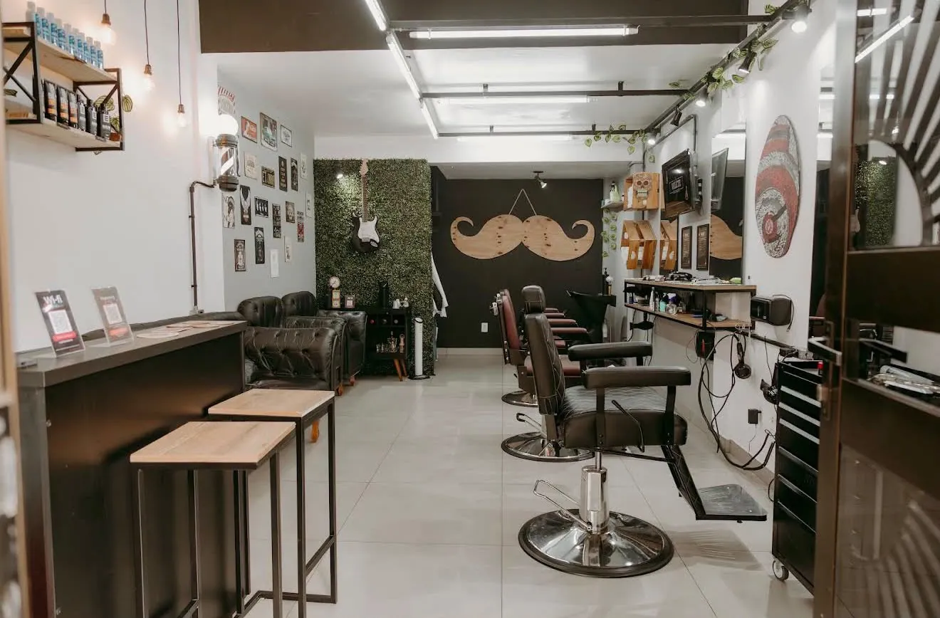 Interior da Valete Barbearia com balcão, poltronas de couro e cadeiras de barbeiro